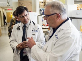 The Ottawa Hospital's Dr. Derek Jonker, left, and Dr. John Bell, speak to reporters about a clinical trial that uses a combination of viruses to treat cancer, in a lab at the Ottawa Hospital Friday July 10, 2015.