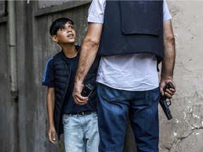 A Turkish police officer asks questions to a young Kurdish boy after an attack against Turkish police officers in the centre of Diyarbakir on July 23, 2015. A Turkish police officer was shot dead and a second one wounded today in the mainly Kurdish city of Diyarbakir in the latest in a series of attacks that began with a suicide bombing blamed on ISIL, security sources said.