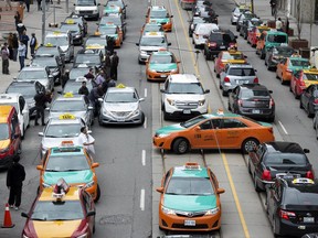 Taxi divers block traffic during a protest against Uber on Queen Street in front of City Hall in Toronto, Ontario, Monday June 1, 2015. Cab drivers say they are fed up losing business to the transportation app.