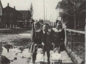 Two girls accompanied by a boy take their dolls for a stroll along main street's wooden sidewalks in Stittsville in 1915. There is a way to plan for Stittsville's future while respecting its heritage, writes Jonathan McLeod.