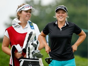 During the final round, Brooke Henderson waits at the 14th hole with her sister, Brittany, who was caddying for her at the Open.