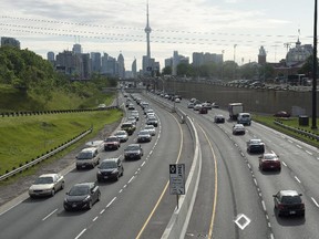 Vehicles crawl past the nearly empty Pan Am high-occupancy vehicle lanes during morning rush hour in Toronto in June. A report calls on the province to allow all drivers willing to pay a fee to use HOV lanes.