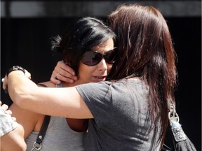 Widow Nadia Robinson is comforted outside the Elgin Street courthouse Wednesday July 8, 2015.