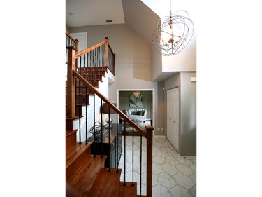 The entryway sets the tone with re-stained stairs, new wrought-iron spindles, fun hexagon tiles and a bold wrought-iron-and-crystal chandelier from Multi Luminaire. 'Lise wanted a little bit of bling,' Tait says.