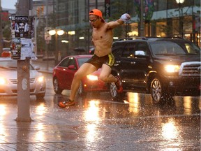 A jogger takes a huge puddle on Sussex Drive at full leap as he made his way through the downtown amidst the torrential thunderstorm that struck Wednesday evening. (Julie Oliver / Ottawa Citizen)
