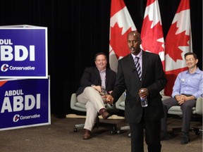 Abdul Abdi (centre) kicked-off his election campaign with a event at Centrepointe iWednesday. Ministers Jason Kenney (left) and Pierre Poilievre (right) were there to lend their support.
