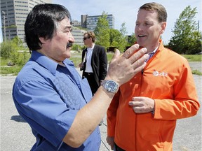 Algonquins of Pikwakanagan Chief Kirby Whiteduck, left, chats with Windmill Development executive chairman, Jeff Westeinde, after a press conference at the future of site of Windmill Development's Zibi project on the Gatineau side of the Chaudiere Falls Thursday May 21, 2015. The project is the first one in Canada to be endorsed by UK-based Bioregional as a One Planet Community.