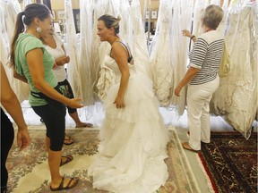 Anick Langlais. center, searches for a wedding dress during the McCaffrey bankruptcy sale at in Ottawa Thursday August 20, 2015.  Langlais lined up at 6:30 a.m. to get a chance to find the perfect dress. The sale runs until Sunday or until the last dress is sold.