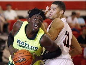 The Baylor Bears' Johnathan Motley, left, sneaks past the Carleton Ravens' Guillaume Payen Boucard in the early game on Friday Aug. 14, 2015.