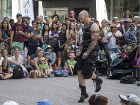 British escape artist Rob Roy Collins performs a Riverdance  at the Ottawa International Buskerfest Saturday, before climbing a ladder to escape his chains.