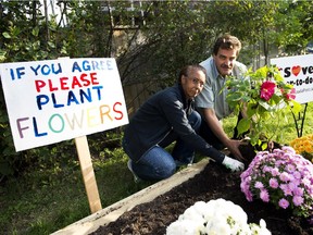 Catherine Fortuné and her husband Tim Martin plants a flower at a garden which the couple and some of the neighbours helped build as a protest at a site where Canada Post plans to build a community mailbox on Tuesday, Aug. 25, 2015.