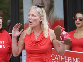 Catherine McKenna, the Liberal candidate in Ottawa Centre, holds a new pair of red sneakers as she speaks during a campaign launch rally outside her campaign headquarters on Somerset St. W. in Ottawa, Sunday, August 2, 2015. McKenna's rally was held just hours after Prime Minister Harper triggered the official start of October 19 election campaign. Mike Carroccetto / Ottawa Citizen
