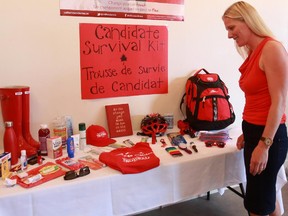 Catherine McKenna, the Liberal candidate in Ottawa Centre, looks at items in her 'survival kit' during a campaign launch rally at her campaign headquarters on Somerset St. W. in Ottawa, Sunday, August 2, 2015.