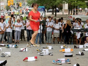 Crack addict Jennifer Bigelow, 47, addresses the small crowd at the Human Rights Memorial. Forty-five pairs of shoes were scattered at the base of the memorial Monday to honour the 45 drug overdose deaths in the past year in Ottawa.