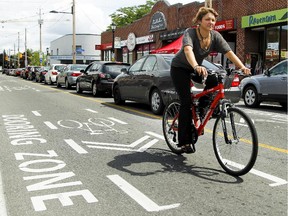 A cyclist is seen passing through the 'dooring zone' on Wellingston street on Saturday, Aug. 8, 2015.