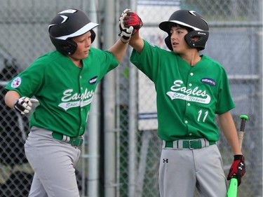 East Nepean Eagles' #11 Nick Pilieggi, right, celebrates a run scored by teammate Ben Anderson in the bottom of the first inning.