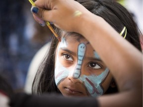 Five-year-old Nadia Khan has her face painted at the SouthAsianFest held outside city hall on Saturday, Aug. 15, 2015.