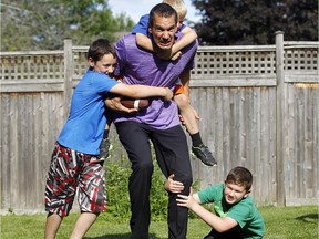 Francois Bordeleau plays with his sons, from left, Sebastien, Xavier and Alexandre in their Barrhaven backyard.