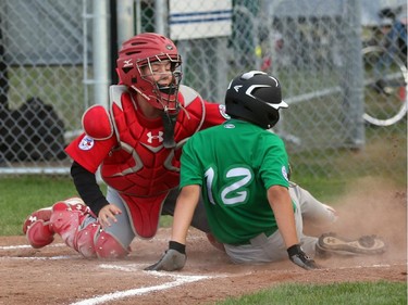 Glace Bay (Nova Scotia) McDonalds Colonels' catcher #28 Mitchell MacDonald tags out East Nepean Eagles baserunner Tristan Godmaire at home plate on an attempted double steal.