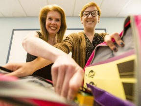 Heather Fraser, left, director of resource development for the Caring and Sharing Exchange, fills some backpacks with volunteer Meredith VanVolkingburgh. The Sharing in Student Success program helps make sure children in need get the proper supplies required for the start of the school year.