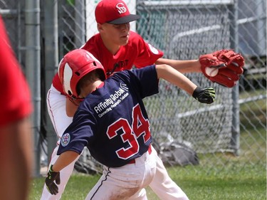 High Park (Toronto) Braves' #34 Taeg Gollert scores on a wild pitch as Lethbridge (Alberta) Red Giants pitcher #27 Ty Wevers attempts a tag.