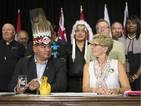 Ontario Regional Chief Isadore Day sits with Ontario Premier Kathleen Wynne as they sign an accord at the Ontario Legislature in Toronto on Monday, Aug. 24, 2015.
