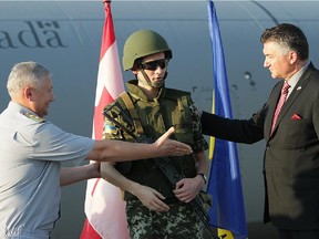 James Bezan, far right, is shown in this Canadian government photo promoting the delivery of surplus Canadian military equipment to Ukraine in August 2014.