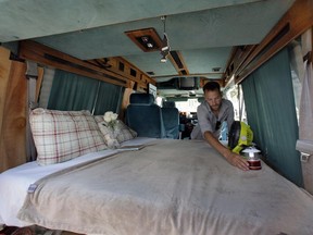 In this Monday, Aug. 3, 2015, photo, Jonathan Powley, who rents parked vehicles on Airbnb, prepares a 1995 Chevrolet conversion van, one of his offerings, in the Queens borough of  New York. While parked vehicles make up only a fraction of the thousands of Airbnb listings in New York City, they provide an option for adventurous, budget-minded visitors seeking a place for far less than the $200-and-up most hotels charge.