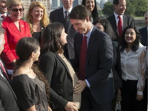 Federal Liberal leader Justin Trudeau greets pregnant candidate Christine Poirie at a morning event Monday  in Montreal.