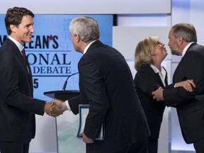 Liberal leader Justin Trudeau, left, shakes hands with Conservative leader Stephen Harper as Green party leader Elizabeth May and NDP leader Thomas Mulcair embrace following the first leaders debate Thursday, August 6, 2015 in Toronto.