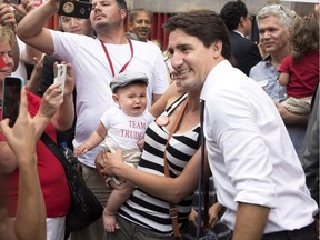 Liberal Leader Justin Trudeau, right, poses with supporters during a campaign stop in Toronto on Monday, August 17, 2015.