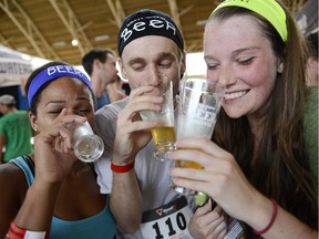 From left, Andrea James, Jackson Welsh and Kayla Fasken enjoy their beers at the Ottawa Craft Beer Festival after running the five-kilometre Beer Run on Saturday, Aug. 29, 2015.