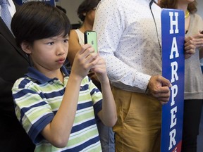 A young supporter takes a souvenir photo of Laureen Harper, daughter of Conservative leader Stephen Harper, while visiting a riding office Wednesday, August 5, 2015 in Richmond Hill, Ont.