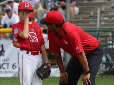 Lethbridge (Alberta) Red Giants pitcher #5 Jaxon Filipenko puts his hand over his face after injuring himself.