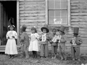 Aboriginal children holding letters that spell "Goodbye" at Fort Simpson Indian Residential School in the North West Territories in 1922.