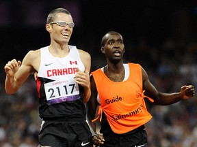 Ottawa's Jason Dunkerley, seen with guide Josh Karanja in a file photo, thought he had won a silver at the Parapan Am Games in Toronto, but he was upgraded to gold after a Brazilian was disqualified.