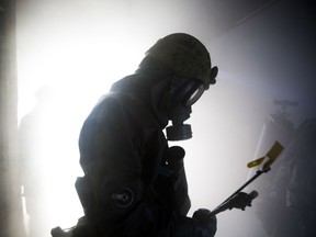 A member of the Japan Ground Self-Defense Force’s 102nd Central Nuclear Biological Chemical Weapon Defense Unit makes his way through a smoke filled room inside the fire training tower aboard Marine Corps Air Station Iwakuni, Japan, Nov. 7, 2014. The 102nd Central NBC Weapon Defense Unit, Marine Aircraft Group 12, and the MCAS Iwakuni Fire Station collaborated to conduct interoperability training  while executing Chemical Biological Radiological Nuclear and Hazardous Material Emergency Response Operations.