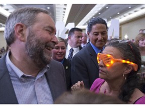 NDP Leader Tom Mulcair laughs as his wife Catherine wears a pair of light up sunglasses as they attend a campaign rally in Vancouver, Sunday, August 9, 2015.