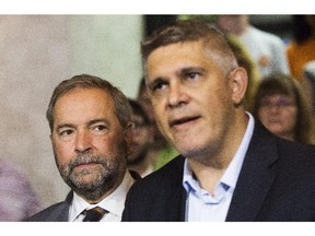 NDP Leader Tom Mulcair, left, announces during a press conference that former Saskatchewan finance minister Andrew Thomson, right, will run as an NDP candidate in the Toronto riding of Eglinton-Lawrence against Conservative incumbent Joe Oliver in Toronto on Friday, August 14, 2015.