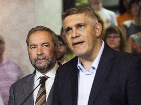 NDP Leader Tom Mulcair, left, announces  that former Saskatchewan finance minister Andrew Thomson, right, will run as an NDP candidate in the Toronto riding of Eglinton-Lawrence against Conservative incumbent Joe Oliver in Toronto on Friday, Aug. 14.