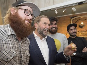 NDP Leader Tom Mulcair shows off a bottle of beard oil during a campaign stop in St. Catharines, Ont., on Thursday, August 27, 2015.