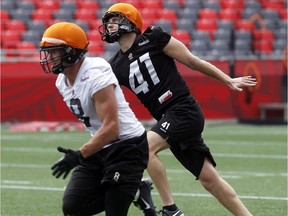 New Ottawa Redblacks kicker, Andy Wilder, 41, watches his ball in the air while Jake Harty, 8, tracks it down during practice at TD Place Wednesday.