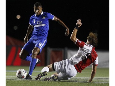 New York Cosmos' Rovérsio Rodrigues de Barros (6) eludes a slide tackle from Ottawa Fury's Tom Heinemann (9).