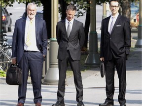 Nigel Wright, centre, former chief of staff to Prime Minister Stephen Harper, arrives at the Ottawa courthouse on Tuesday, Aug. 18, 2015, to testify at the Mike Duffy trial.