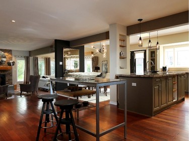 A support beam running the length of the space marks where the addition begins. In the foreground, repurposed restaurant equipment has become a stand-alone metal island that makes use of dead space between the entryway and kitchen. 'It's all beaten up, but that's what I like about it,' says homeowner Lise Thibault.