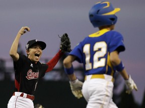 East Nepean's David Legault, left, celebrates after Brno, Czech Republic's Krystof Jan Hruza (12) grounded out to end a baseball game in International elimination play at the Little League World Series tournament  in 2013. Canada won 4-3.
