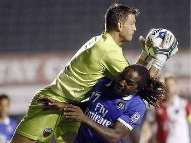 Ottawa Fury's goalkeeper Romuald Peiser (1) grabs the ball overtop New York Cosmos' Lucky Mkosana (77).