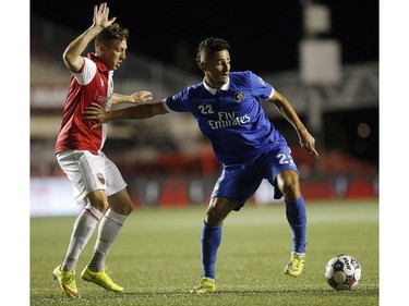 Ottawa Fury's Oliver Minatel (11) is pushed off the ball by New York Cosmos' Leonardo Fernandes (22).