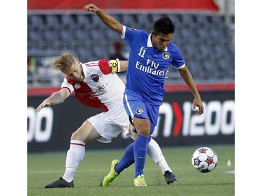 Ottawa Fury's Richie Ryan (6) challenges New York Cosmos' Andrés Alexander Flores Mejía (11) for the ball.