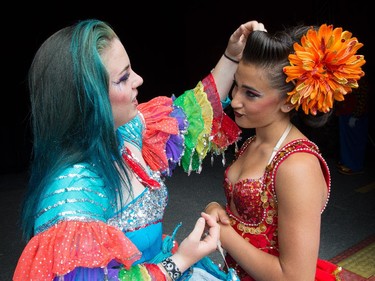Performers Harley Curtis, left, and Ysabella Cortes fix their outfits before going on stage.